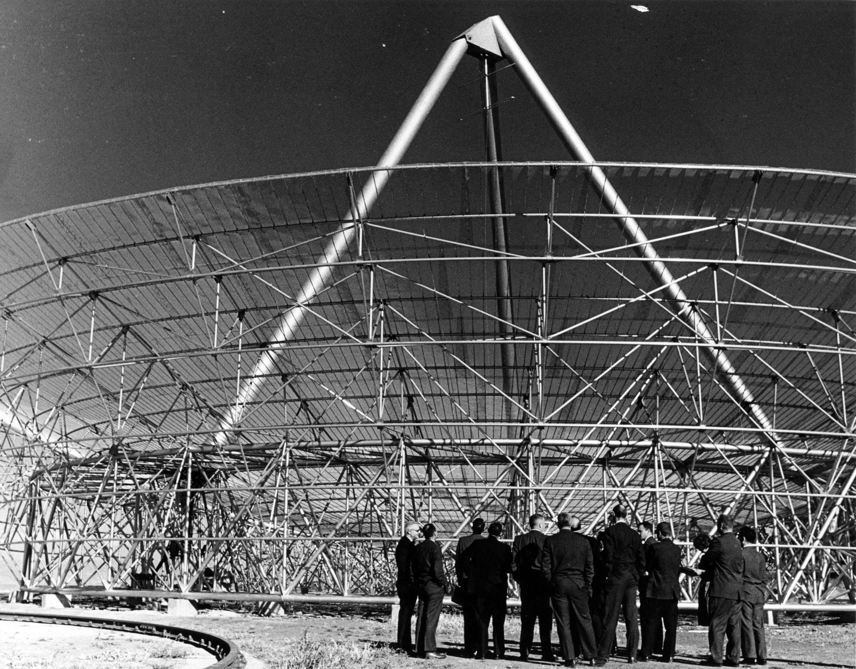 Several men standing together, examining a large structure.